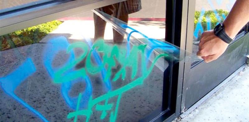 window film with grafitti being peeled off